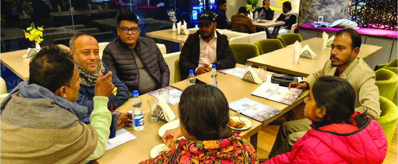 Eight adults in conversation around tables, with printed material in front of them